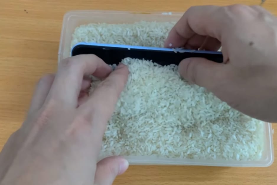 Put phone in bowl of dry rice to absorb the water